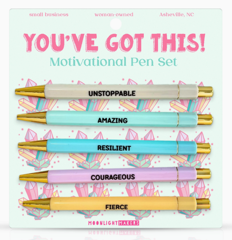 Motivational pen set with pens labeled 'Unstoppable', 'Amazing', 'Resilient', 'Courageous', and 'Fierce' on a decorative card.