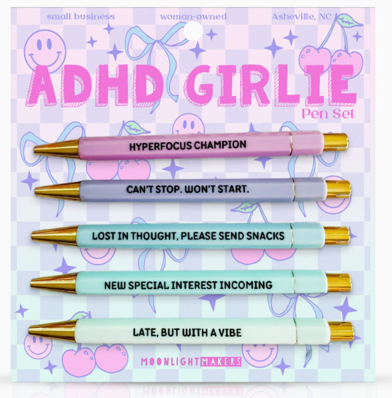 Pen set with colorful pens and humorous text on a pastel background, branded as 'ADHD GIRLIE'.