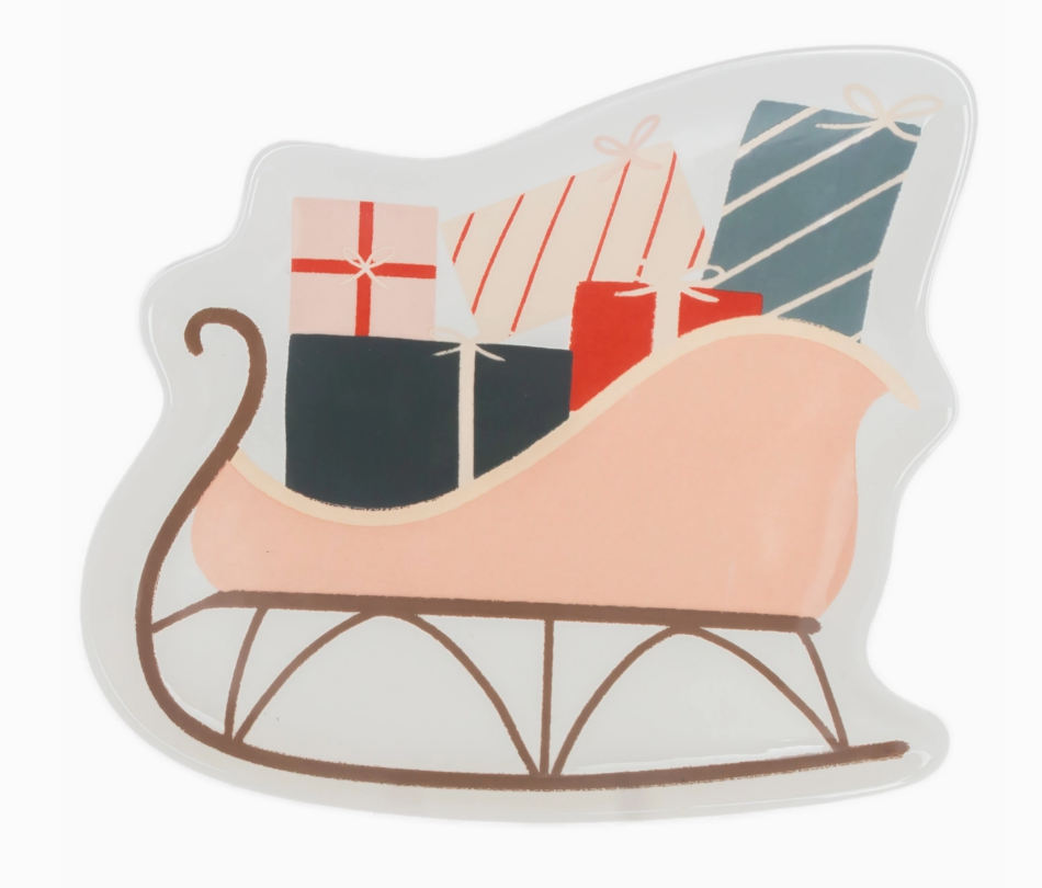 Decorative ceramic plate shaped like a sleigh with wrapped gifts on a white background