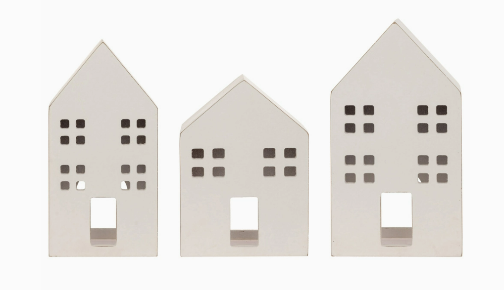 Three white house-shaped candle holders on a white background